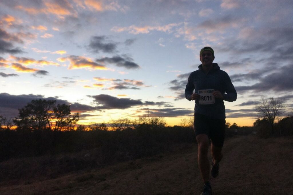 Silhouette d'un coureur avec un dossard au crépuscule