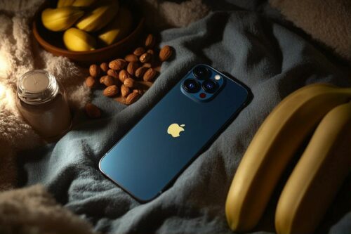 Smartphone bleu sur tissu gris entouré de bananes et d'amandes